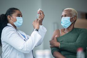 Doctor prepares to give patient a vaccine.