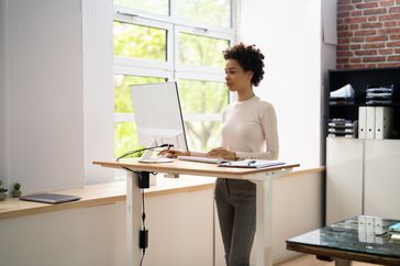 Woman standing at a standing desk.