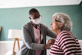 Doctor using a stethoscope to check a patient's heart.