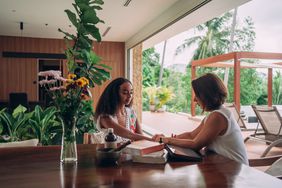 An ayurvedic therapist is checking person's pulse during a consultation