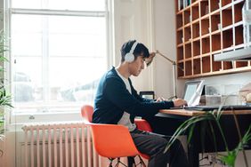 man with headphones working on laptop