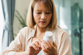 A woman holds medicine searching information 
