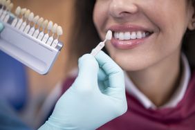 dentist using a tooth palette to fit a person with a dental crown