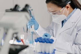 Scientist is adding reagents to microscope slide in laboratory for endometrial biopsy