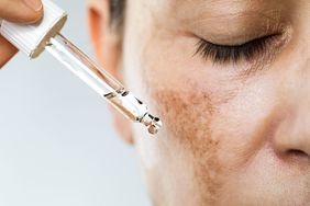 Woman putting oil on her face