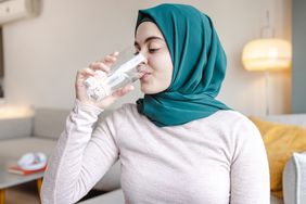 A woman drinks a glass of water