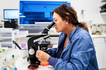 Lab technician examining skin cells for erythrodermic psoriasis