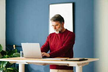 older man standing desk