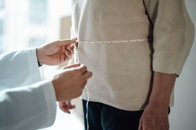 doctor measuring patient's waist