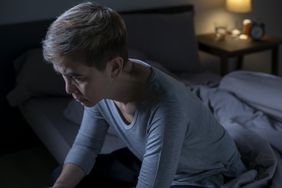 Person sitting up in bed, sleepwalking