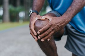A runner holds his bent knee