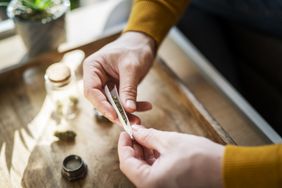 Man rolling a marijuana joint.