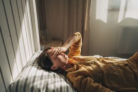 person with mental health condition feeling sad while laying down on bed