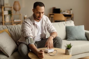man checking blood pressure at home