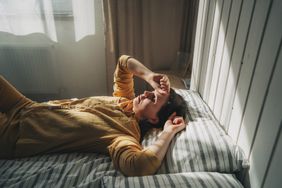 Tired woman lies on the bed