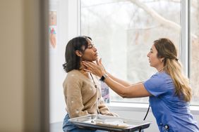 doctor examining person's lymph nodes