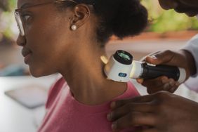 Dermatologist examining back of patient's neck for carbuncle