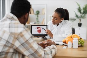Doctor showing patient image of GI tract and talking about the microbiome