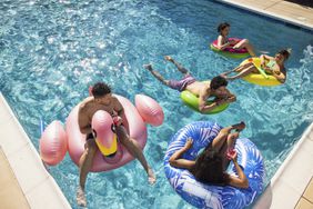 Five people on floats in a pool.