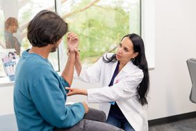 Doctor examining patient's arm