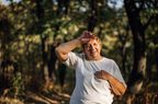 Older woman sweating outside on a run.