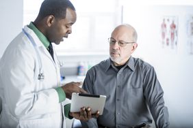 A male doctor shows a male patient results