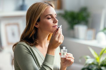 person smelling essential oils to help relieve stuffy nose