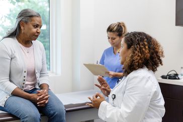 Doctor talking to patient about multiple myeloma treatment, nurse taking notes