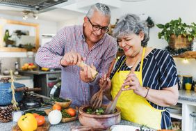 older couple in kitchen making healthy food