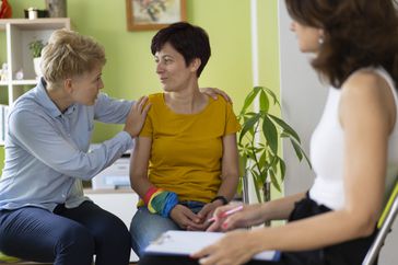 Person supporting loved one during eating disorder therapy session