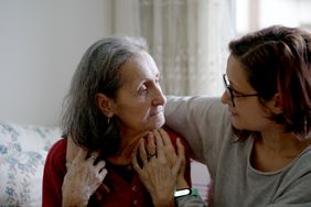 young adult putting arm over the shoulders of an older adult to offer support