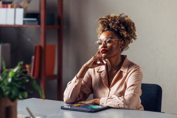 A person sits at the desk and looks a little stressed out.