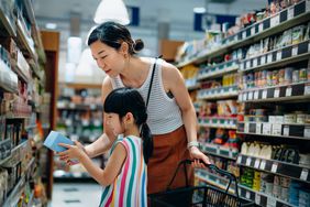 woman and young girl looking at food label
