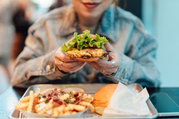 woman experiencing extreme hunger holding crispy fried mushroom burger