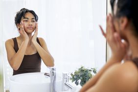 a person applying lotion to their face