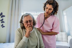 Doctor examining person coughing.
