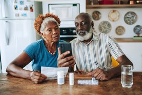 Couple looks at their phone and reads instructions to take their medicine.