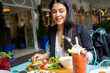 Person eating Mediterranean diet at a restaurant.