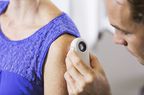 Dermatologist examining patient's upper arm
