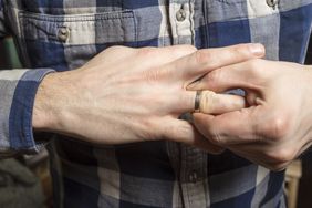 Person trying to remove stuck ring from finger