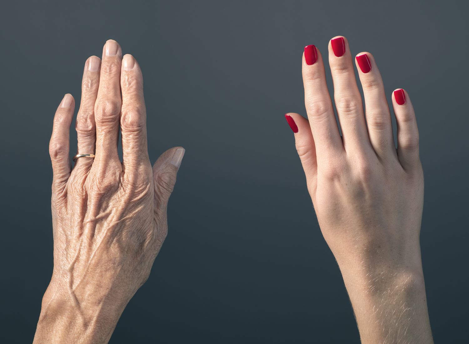 elderly woman's hand beside young woman's hand