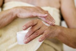 woman applying lotion to hands after shower