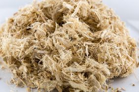 Close up of slippery elm shaved inner bark: Light tan thin wood pieces in a pile