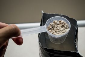 Hand measuring whey protein powder