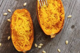 Overhead view of spaghetti squash; orange, ovular squash with spaghetti-like strands of flesh.