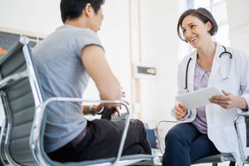 A female doctor talks with a patient as they sit across from each other in chairs