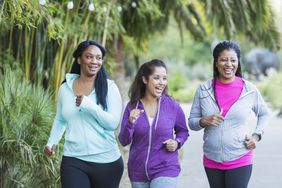 Three people walking quickly or running in the park together