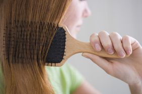 A person brushes their hair