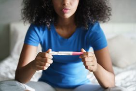 Person holding and looking at pregnancy test