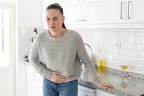 Woman with constipation in the kitchen